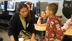 A student talks about their poetry while his guest listens.