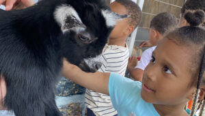A student meets the baby goat.