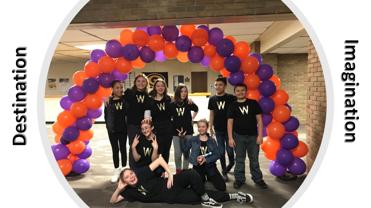 Students standing under a balloon arch