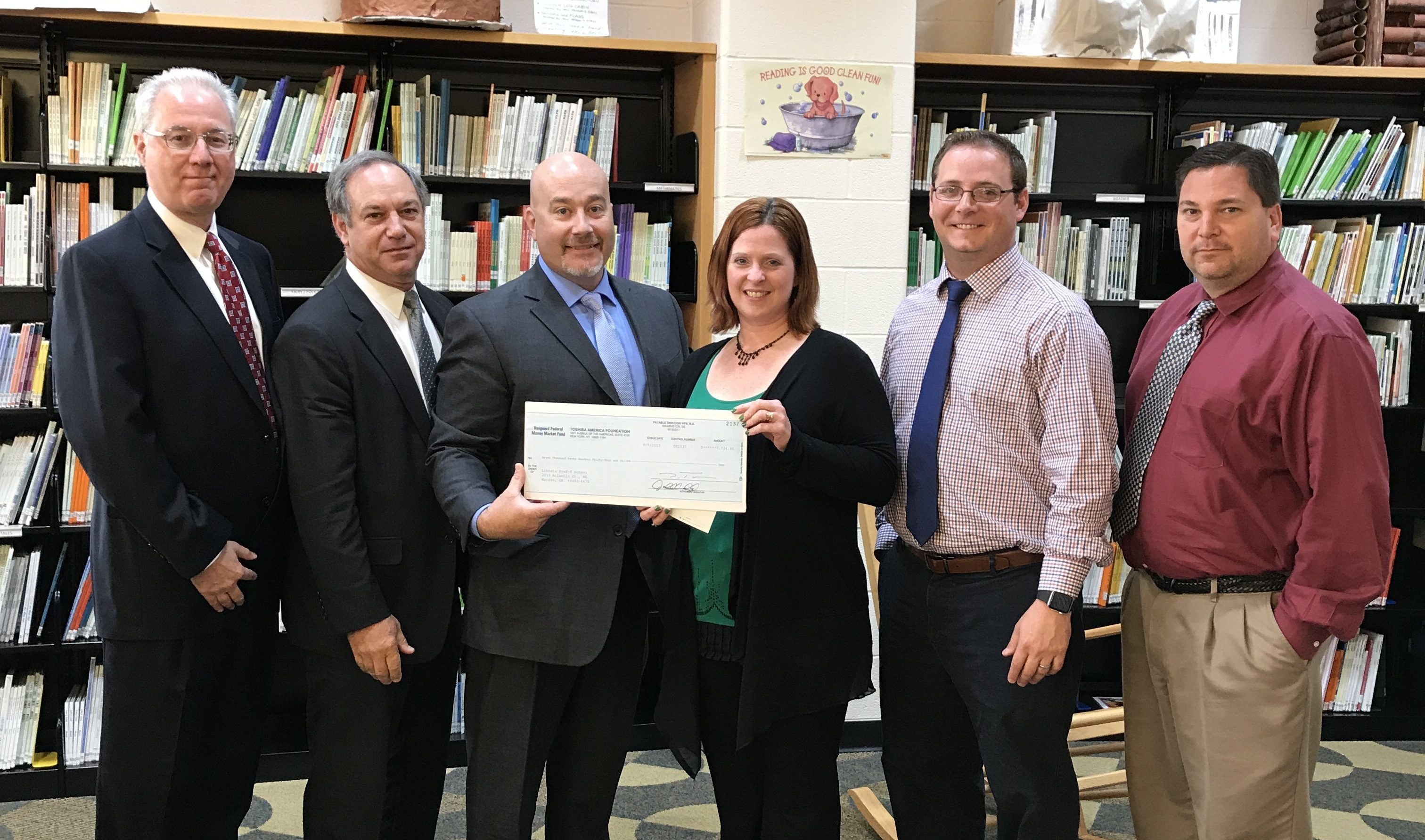 Christine Depascale, John DeSantis, and Steve Chiaro pose for a picture as representatives from Toshiba present them with a check to fund two 3D printers
