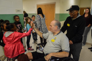 A Warren Rotary Club Member gives high fives to students after a dictionary giveaway