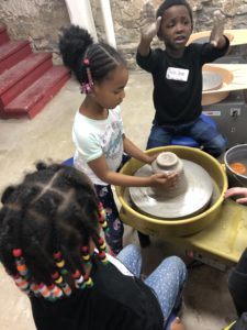 Students create pottery at potters wheel