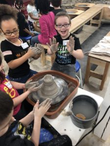 Students create pottery at potters wheel